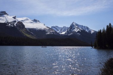 Yaz manzarası ve Maligne gölünde kayak yapan ve balık tutan insanlar, Kanada 'da Jasper Ulusal Parkı