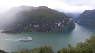Yağmurlu bir günde Geiranger Fjord, Norveç 'i geçen bir gemi gezisi sahnesi.