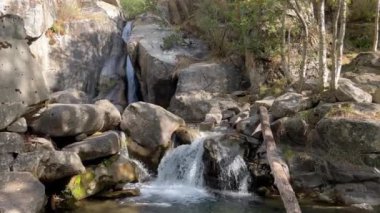 La Cerdanya, Pyrenees, İspanya 'da yaz mevsimi. Etrafı kayalar ve yemyeşil yeşilliklerle çevrili sakin bir şelale sergileniyor..