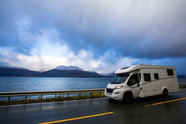 Norveç 'in Lyngen Alpleri' nin sonbahar manzarasında yol kenarına parketmiş bir karavan..
