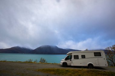 Norveç 'in Lyngen Alpleri' nin sonbahar manzarasında yol kenarına parketmiş bir karavan..