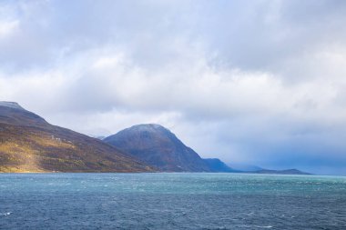 Norveç 'teki Lyngen Alpleri' nin sonbahar manzarası. Karlı zirveleri, dramatik bulutları ve sakin fiyortları var..