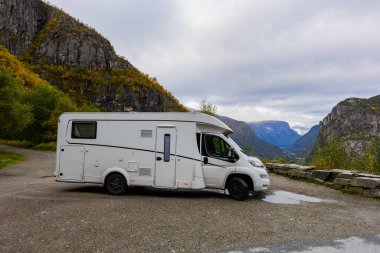 Norveç 'in Steine kentindeki Hagatunnel yolunda dramatik dağlarla çevrili manzaralı bir viraja park edilmiş bir karavan..