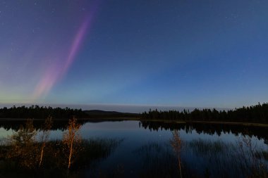 İsveç 'in Kiruna kentindeki kuzey ışıkları Eylül ayında sakin suları yıldızlar ve ormanlarla yansıtıyor..