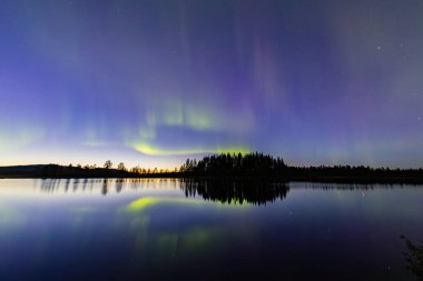 İsveç 'in Kiruna kentindeki kuzey ışıkları Eylül ayında sakin suları yıldızlar ve ormanlarla yansıtıyor..