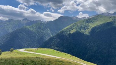 Saint-Aventin 'de yaz mevsimi, Fransız Pireneleri, virajlı dağ yolunda nefes kesici manzaralı bisikletçiler.