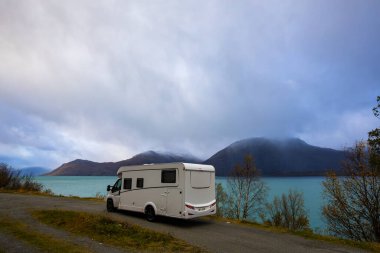 Norveç 'in Lyngen Alpleri' nin sonbahar manzarasında yol kenarına parketmiş bir karavan..