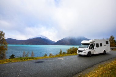 Norveç 'in Lyngen Alpleri' nin sonbahar manzarasında yol kenarına parketmiş bir karavan..