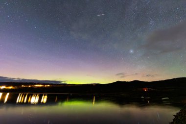 The Northern Lights and Milky Way above the mountains near Dovrefjell National Park, Norway. clipart