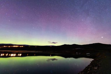 The Northern Lights and Milky Way above the mountains near Dovrefjell National Park, Norway. clipart