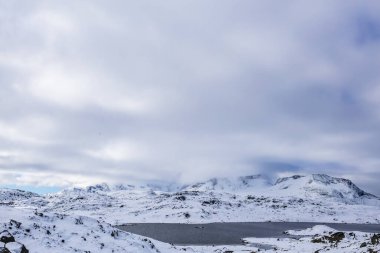 Norveç 'in güneyindeki Sognefjellsvegen yolu boyunca uzanan kış manzarası, karla kaplı dağlar ve geniş, sakin bir arazi içerir..