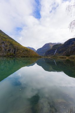 Norveç, Skjolden 'de sonbahar manzarası. Dağları ve renkli yaprakları yansıtan sakin bir göl..