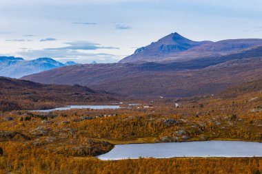 Autumn landscape of Kilpisjarvi, Finland, showcasing colorful foliage, serene lakes, and majestic mountains. clipart