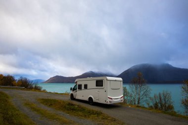 Norveç 'in Lyngen Alpleri' nin sonbahar manzarasında yol kenarına parketmiş bir karavan..