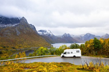 Norveç 'in Senja Adası' nın sonbahar manzarasında, fiyortları ve dağları olan bir karavan..