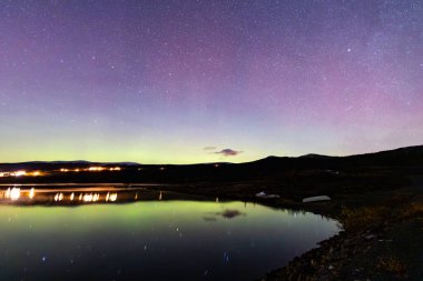 The Northern Lights and Milky Way above the mountains near Dovrefjell National Park, Norway. clipart