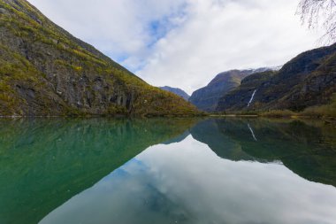 Norveç, Skjolden 'de sonbahar manzarası. Dağları ve renkli yaprakları yansıtan sakin bir göl..