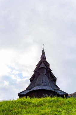 Norveç 'teki Hopperstad Stavkyrkje, güz ağaçları ve huzurlu bir mezarlıkla çevrili tarihi bir ahşap kilise..