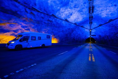 Motorhome inside the Laerdal Tunnel, the longest tunnel in the world, in Norway, with vibrant blue lighting. clipart