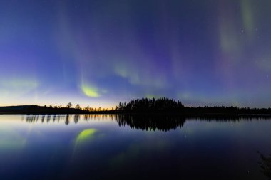 İsveç 'in Kiruna kentindeki kuzey ışıkları Eylül ayında sakin suları yıldızlar ve ormanlarla yansıtıyor..