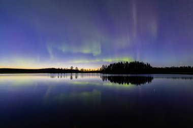 İsveç 'in Kiruna kentindeki kuzey ışıkları Eylül ayında sakin suları yıldızlar ve ormanlarla yansıtıyor..
