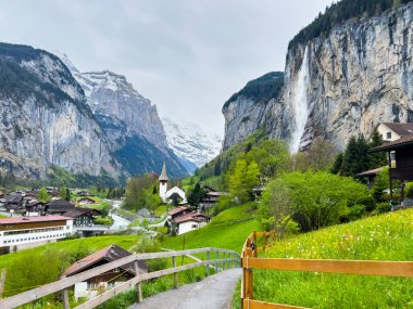 Lauterbrunnen, İsviçre; 5 Mayıs 2024: Lauterbrunnen, İsviçre 'de büyüleyici şelaleler, dağ manzaraları ve büyüleyici köy manzaralarıyla güzel bir bahar günü. 4K UHD