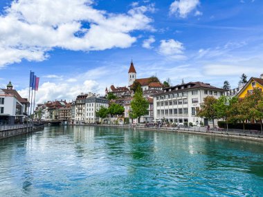 Thun, İsviçre; 5 Mayıs 2024: Thun, İsviçre 'de tarihi binalar, akan bir nehir ve güzel bir gökyüzü ile büyüleyici bir bahar sahnesi. 4K UHD