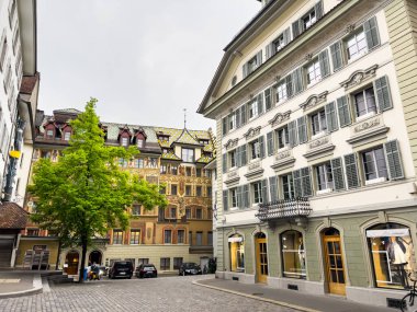 Lucerne, İsviçre; 6 Mayıs 2024, Lucerne, İsviçre 'de tarihi binaları ve bulutlu gökyüzü olan bir teknenin yer aldığı bahar günü. 4K UHD