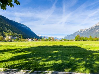 İlkbaharda Interlaken, İsviçre 'de güzel binalar, sakin bir nehir ve çarpıcı bir dağ sergileniyor..