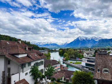 Thun, İsviçre 'de büyüleyici bir bahar sahnesi, tarihi binalar, akan bir nehir ve güzel bir gökyüzü. 4K UHD
