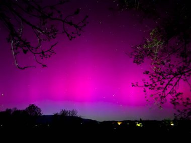 La Cerdanya, Pyrenees, İspanya 'da gece gökyüzünde dans eden canlı mor ve mor kuzey ışıkları. Mayıs 2024