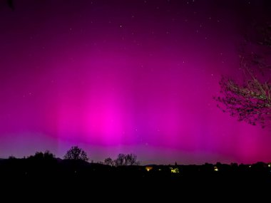 La Cerdanya, Pyrenees, İspanya 'da gece gökyüzünde dans eden canlı mor ve mor kuzey ışıkları. Mayıs 2024