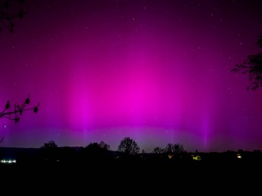 La Cerdanya, Pyrenees, İspanya 'da gece gökyüzünde dans eden canlı mor ve mor kuzey ışıkları. Mayıs 2024