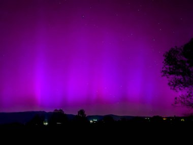 La Cerdanya, Pyrenees, İspanya 'da gece gökyüzünde dans eden canlı mor ve mor kuzey ışıkları. Mayıs 2024