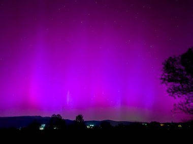 La Cerdanya, Pyrenees, İspanya 'da gece gökyüzünde dans eden canlı mor ve mor kuzey ışıkları. Mayıs 2024