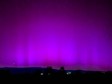 La Cerdanya, Pyrenees, İspanya 'da gece gökyüzünde dans eden canlı mor ve mor kuzey ışıkları. Mayıs 2024