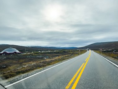 Norveç 'teki dağlık bir arazide bulutlu bir gökyüzünün altında uzanan manzara rotası