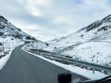 A winter landscape along the Sognefjellsvegen road in south Norway, featuring snow-covered mountains and a vast, serene terrain. clipart