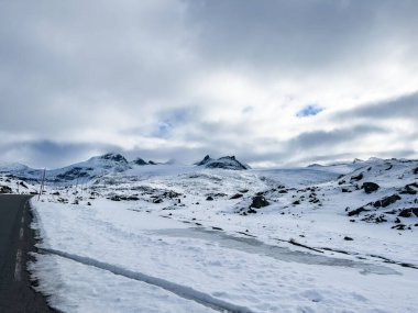 Norveç 'in güneyindeki Sognefjellsvegen yolu boyunca uzanan kış manzarası, karla kaplı dağlar ve geniş, sakin bir arazi içerir..