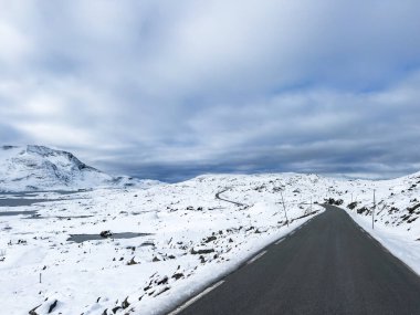 Norveç 'in güneyindeki Sognefjellsvegen yolu boyunca uzanan kış manzarası, karla kaplı dağlar ve geniş, sakin bir arazi içerir..