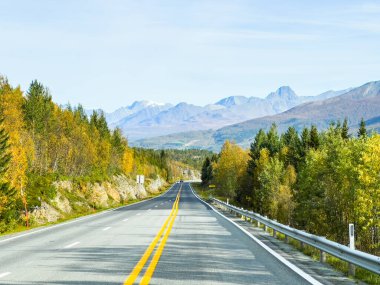 İsveç 'in Kiruna şehrinde sonbahar yeşillikleri ve güzel göl manzaralı bir yolda karavanla yolculuk yapmak..