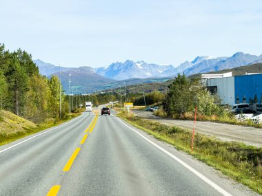 İsveç 'in Kiruna şehrinde sonbahar yeşillikleri ve güzel göl manzaralı bir yolda karavanla yolculuk yapmak..