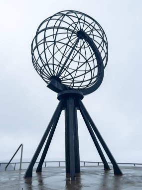 Monumental steel globe at the northernmost point of norway, symbolizing the end of the world clipart