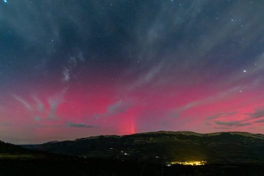 Aurora Borealis Serra Del Montsec, Lleida, İspanya üzerinde gece gökyüzünü canlı kırmızı renklerle boyuyor. Ekim 2024