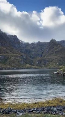 Su dağları ve Norveç 'teki bulutlu gökyüzünü yansıtır.