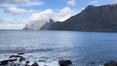 Norveç, Senja 'da dağlar ve bulutlarla kayalara çarpan dalgalar