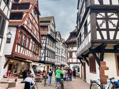 Strasbourg, Fransa; 7 Mayıs 2024: Strasbourg, Fransa 'da bahar mevsimi, parlak bir gökyüzüne sahip güzel bir nehir boyunca yarım ahşap binalar sergiliyor. 4K UHD