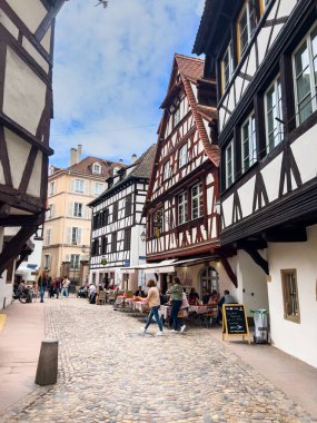 Strasbourg, Fransa; 7 Mayıs 2024: Strasbourg, Fransa 'da bahar mevsimi, parlak bir gökyüzüne sahip güzel bir nehir boyunca yarım ahşap binalar sergiliyor. 4K UHD