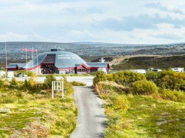 Saltfjellet, Norveç; 9 Eylül 2024: Kuzey Kutup Dairesi merkezine yakın bir karavan park etmek, dalgalanan bayraklar ve uzakta geniş bir kutup manzarası