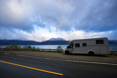 Norveç 'in Lyngen Alpleri' nin sonbahar manzarasında yol kenarına parketmiş bir karavan..